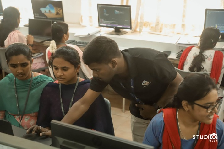Students working with mentor in coding lab